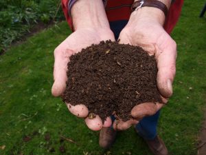Composteermachine maakt handenvol verse compost